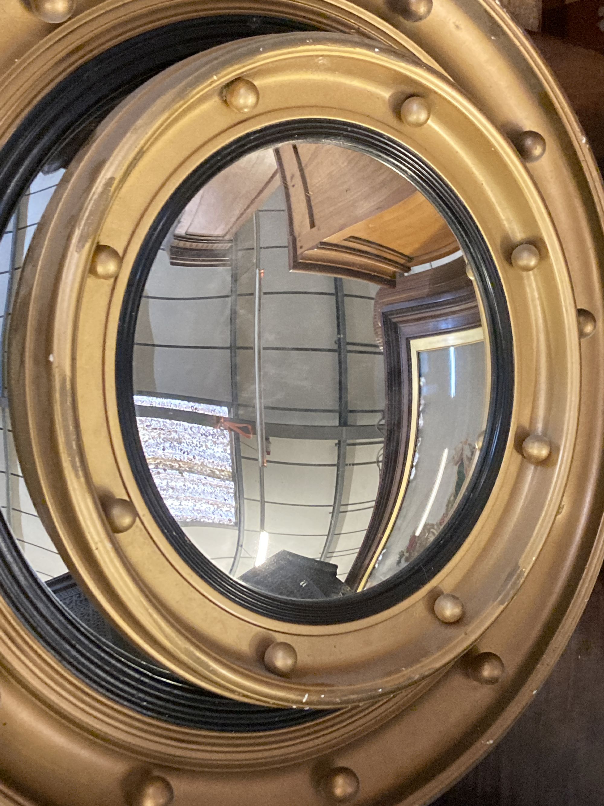 Five gilt and brass framed circular convex wall mirrors, largest 50cm diameter